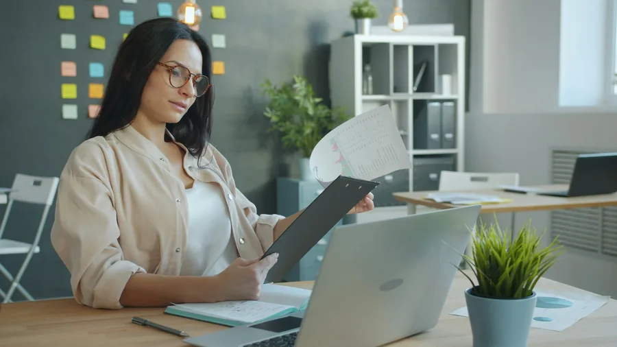 Illustrative stock photo: person working with documents and a laptop